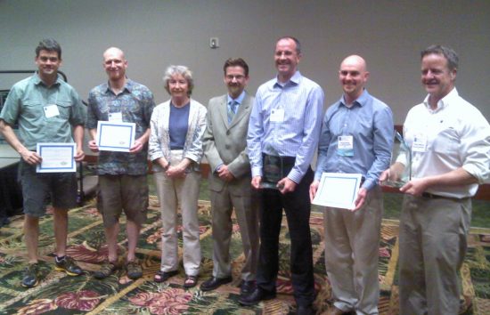 Dr. Rodney Cluck and Dr. Joan Cleveland posing with winners of the FY13 Award for Excellence in Partnering. Left to Right: Dr. Joseph Needoba (CMOP Oregon Health and Sciences U.), Dr. Rob Campbell (Prince William Sound Science Center), Dr. Joan Cleveland (ONR), Dr. Rodney Cluck (BOEM), Dr. Andrew Barnard (Principal Investigator, WET Laboratories), Dr. Corey Koch (WET Labs), and Mr. Casey Moore (WET Labs)